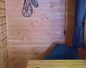 Gezellige hoek in Vakantiehuisje in Wapenveld, Veluwe, Gelderland met houten wanden en decoratie.