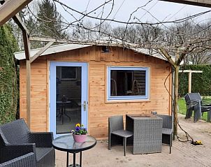 Zonnig terras met zitgelegenheid bij Vakantiehuisje in Wapenveld, Veluwe, Gelderland voor ontspanning in de natuur.