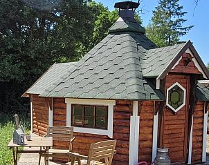 Charmante buitenkant van Vakantiehuis in Overdinkel, Twente, met houten terras en tuinmeubilair.