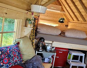 Knusse binnenruimte van Vakantiehuis in Overdinkel, Twente, met comfortabele zithoek en bed.