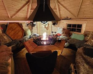 Sfeervolle avond in Vakantiehuis in Overdinkel, Twente, met brandende haard en gezellige inrichting.