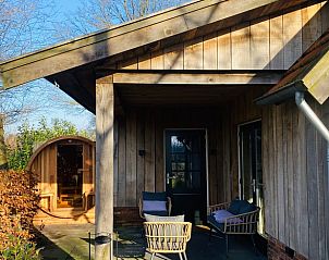 Veranda met zitgelegenheid bij Huisje in Overdinkel, een gezellige B&B in Overijssel, perfect voor ontspanning.
