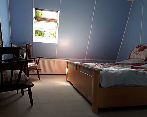 Lichte slaapkamer in Gasthof de Tukkel, Heeten, met uitzicht op de groene omgeving van Salland, Overijssel.