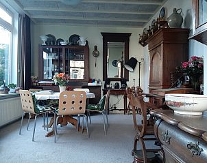 Sfeervolle eetkamer in Gasthof de Tukkel, Heeten, met antiek meubilair en uitzicht op de tuin in Overijssel.