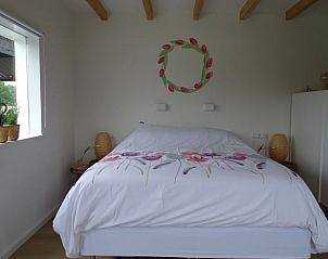 Slaapkamer met bloemenmotief in Huisje in Noordgouwe, bed and breakfast in Noordgouwe, Zeeland.