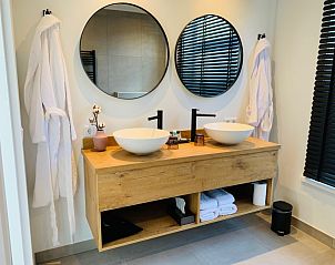 Luxe badkamer in B&B Duinhuys, Walcheren met dubbele wastafel en stijlvolle details.