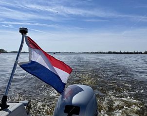 Boottocht met Nederlandse vlag bij Huisje in Nieuwkoop, een bed and breakfast in het Groene Hart van Zuid-Holland.